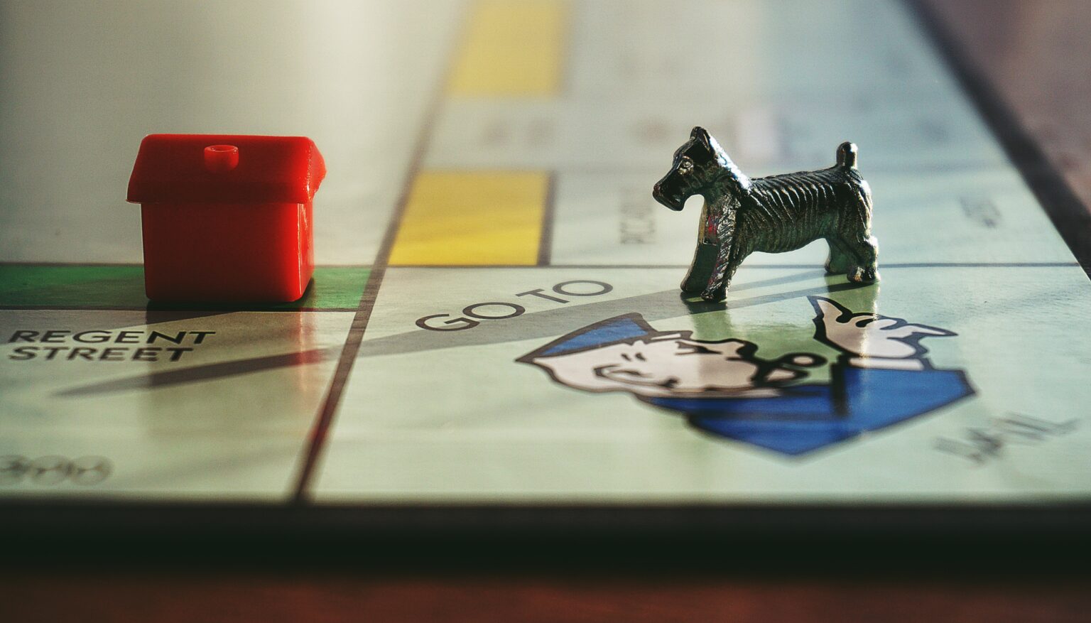 Monopoly board with player pieces on the square that says "go to jail"