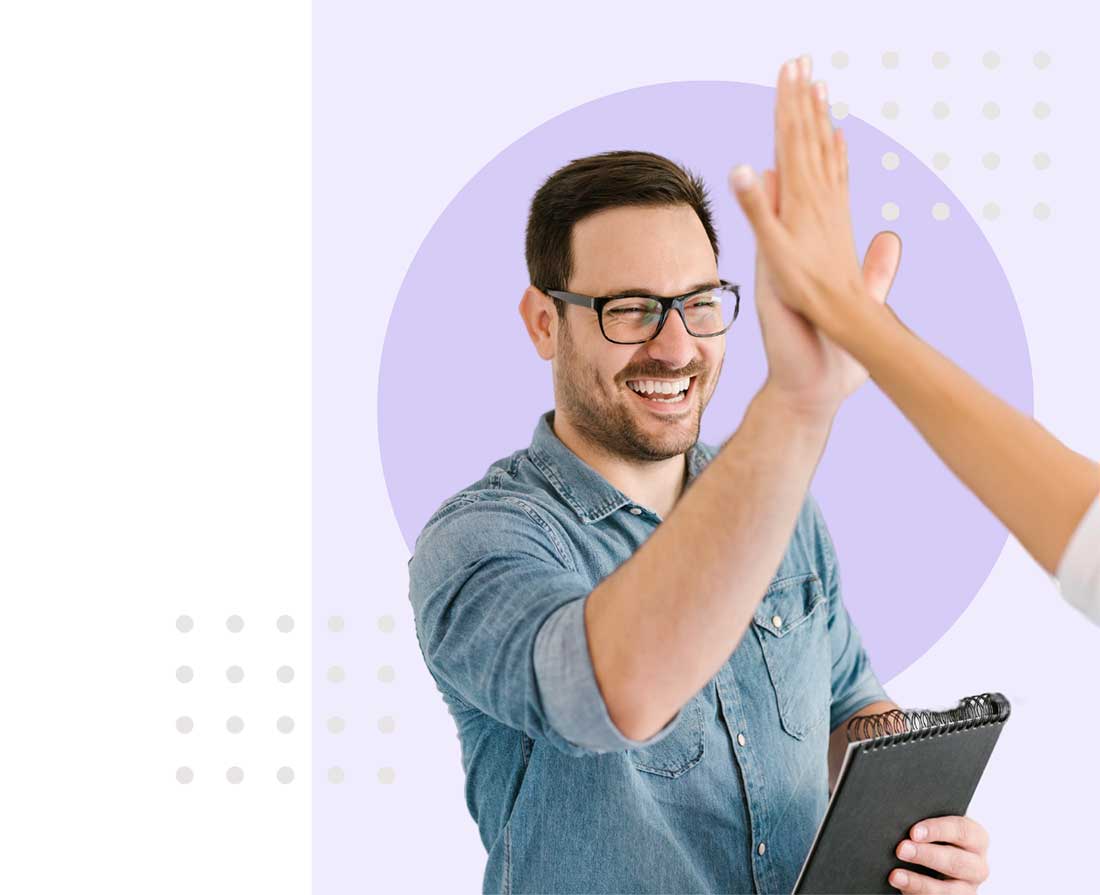 man in front of light purple background decorated with circles, high-fiving someone unseen