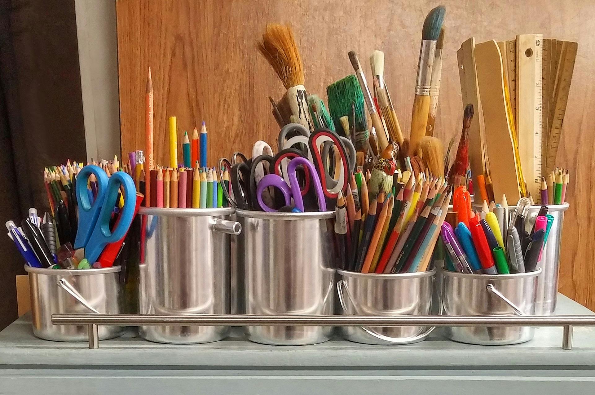 back to school supplies sitting in buckets on a desk