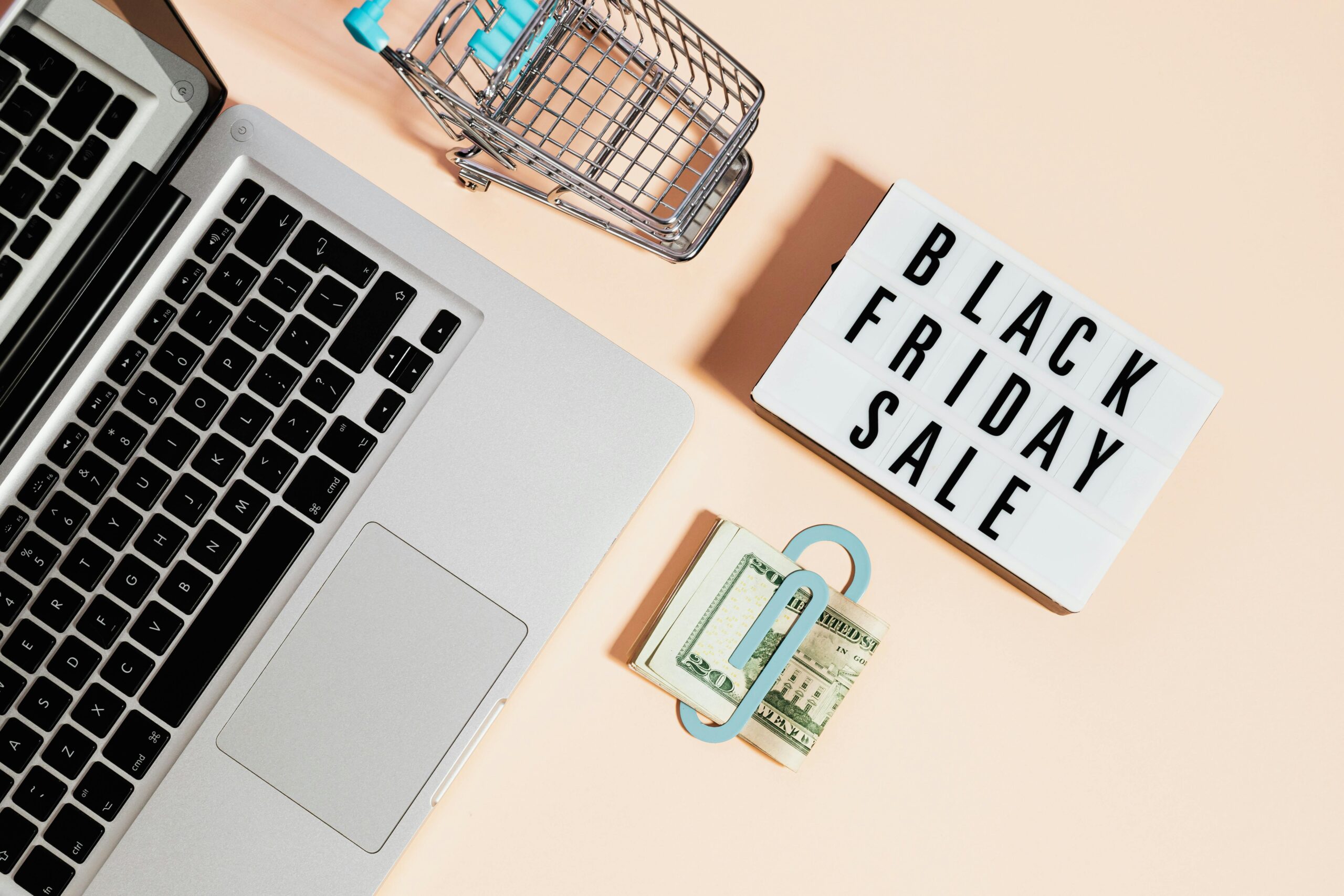 laptop, cash, credit cards, and sign highlight Black Friday Sales, in preparation for BFCM marketing