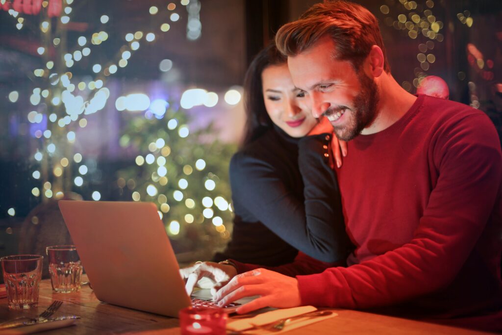 couple doing their holiday shopping on Cyber Monday, smiling at their computer