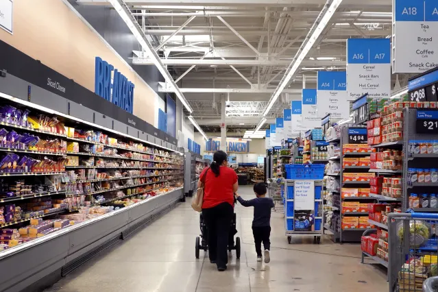 Walmart aisles with a customer pushing a cart down the center